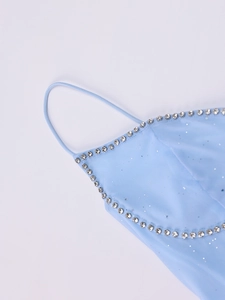 Détail de la robe en maille bleu clair avec sequins et décolleté en strass