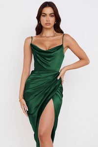 Détail du col bénitier et fines bretelles sur une robe en satin vert foncé à reflets