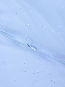 Gros plan sur la fermeture éclair invisible d'une robe en tulle bleu clair à paillettes