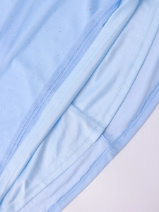 Détail de l'ourlet de robe en tulle bleu clair avec paillettes argentées et coutures fines