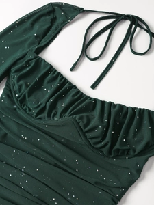Dettaglio dell'abito in mesh verde smeraldo con paillettes scintillanti e busto arricciato