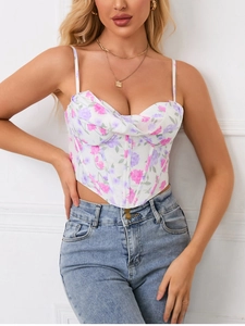 Detailed view of floral corset top with ruched bust and V-hem paired with blue jeans