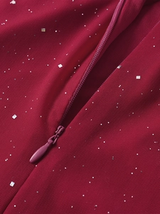 Détail du tissu en maille rouge foncé avec paillettes argentées et fermeture éclair