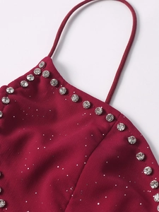 Détail d'une robe en tulle bordeaux à paillettes avec encolure strass et fines bretelles