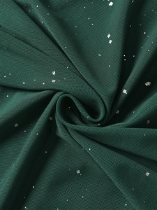 Macro di tessuto mesh verde scuro con paillettes argentate luccicanti e trama delicata