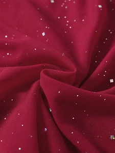 Gros plan sur un tissu en maille rouge foncé avec des paillettes argentées scintillantes