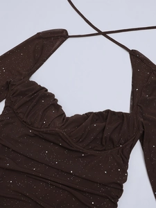 Dettaglio del top a rete con paillettes, scollo a cuore e spalline incrociate sul collo