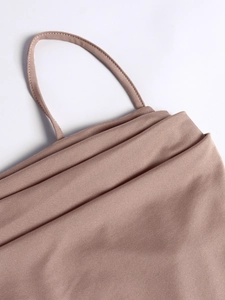 Detail of elegant dusty pink dress showing fine knitted texture and spaghetti straps