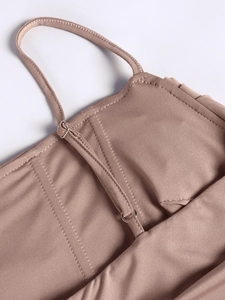 Detail of adjustable thin shoulder strap with silver buckle on mauve summer dress