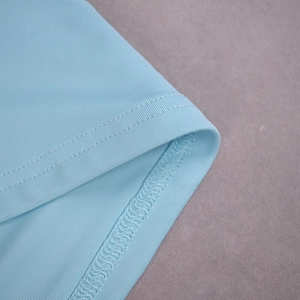 Détail de l'ourlet à double couture et de la maille fine sur une robe bleu clair