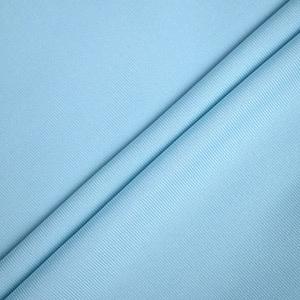 Gros plan sur un tissu en maille piquée bleu clair montrant la texture et le tissage côtelé