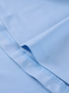 Detailed view of light blue dress fabric featuring high-quality reinforced stitching