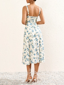 Detail der Kreuzschnürung am Rücken und blauem Blumendruck auf weißem Maxikleid