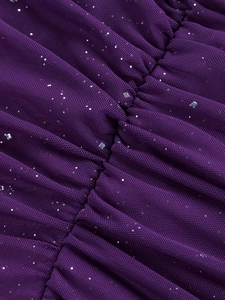 Dettaglio del tessuto in rete viola con paillettes luccicanti e texture arricciata