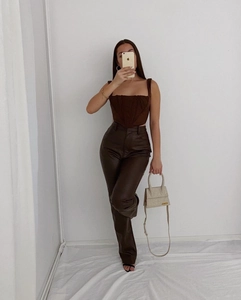 Detail of a brown corset top with boning and matching high-waisted faux leather pants
