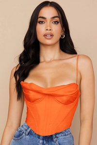 Détail du haut bustier en satin orange vif avec baleines et décolleté drapé élégant