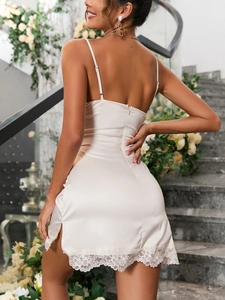Detail of champagne satin dress back featuring thin straps and delicate lace hem