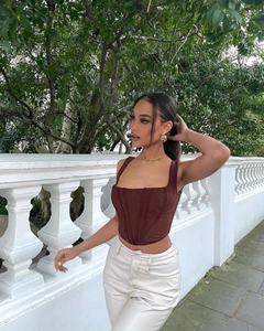 Detail of a chocolate brown corset top with vertical boning and chic square neckline