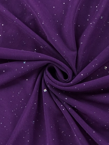 Dettaglio del tessuto a rete viola scuro con paillettes scintillanti e trama delicata