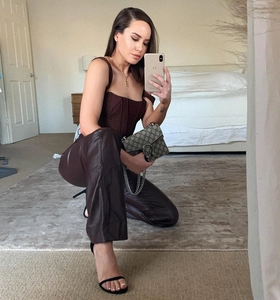 Detail of dark brown corset top with structured boning paired with glossy pants