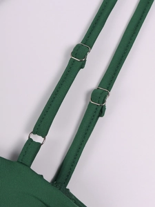 Detail of adjustable double thin straps with silver buckles on dark green fishtail dress