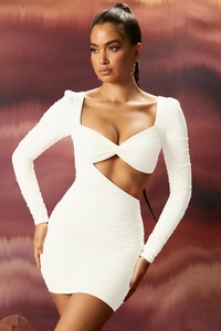 Détail de la robe blanche à manches longues montrant le nœud ajouré et le tissu plissé