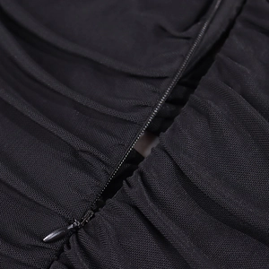 Detail of hidden zipper on black mesh dress showing fine stitching and fabric texture