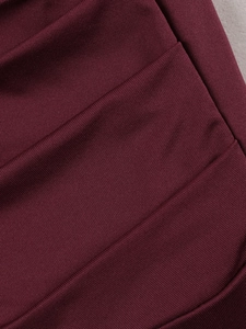 Macro shot of burgundy ribbed knit fabric showing texture and stitching for evening gown