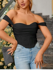 Detail of black strapless corset top with ruched bustier design and denim jeans