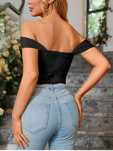 Detail of corset-style back with hidden zipper on a black cropped off-the-shoulder top