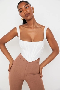 Close-up of white corset top featuring structured boning seams and square neckline detail