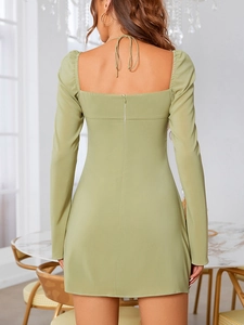 Vista posteriore di miniabito verde chiaro con schiena scoperta ed elegante scollo all'americana