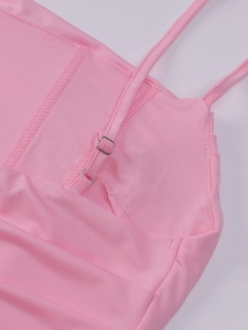 Detail of light pink dress featuring adjustable straps and silver metal buckles