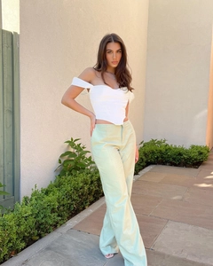 Detail of white corset top with boning and light green high-waisted wide-leg trousers