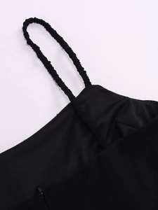 Détail de la robe noire avec bretelles plissées extensibles et fermeture éclair invisible