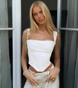 Detail of white square neck corset top featuring elegant pleats and pointed hemline