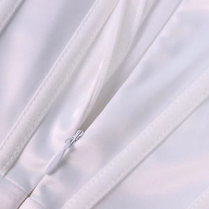 Détails de la fermeture éclair invisible et des baleines de maintien sur robe blanche