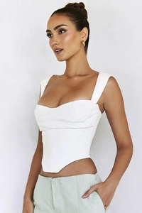 Detailed side view of white corset top with boning structure and ruched front design