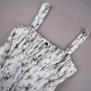 Detailansicht eines weißen Blumenkleides mit grünem Print und gerafftem Kordelzug-Ausschnitt