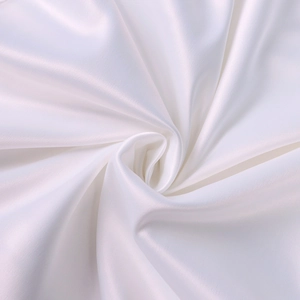 Vue détaillée du tissu en satin blanc lisse avec un drapé élégant et un éclat luxueux