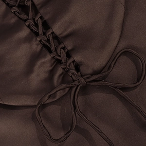 Detail of coffee satin dress featuring intricate criss-cross lace-up ties and smooth texture