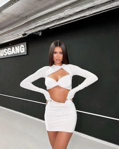 Detail of white two-piece set featuring cutout long sleeve top and ruched mini skirt