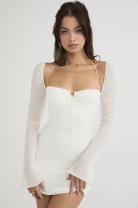Dettaglio dell'abito corto bianco con scollo quadrato e maniche a campana eleganti
