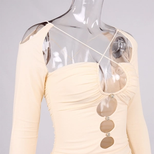 Dettaglio dell'abito beige arricciato in mesh con fibbie di strass e design con cut-out