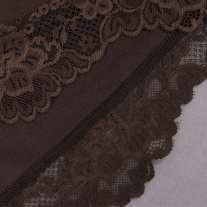 Close-up of deep brown satin fabric with intricate floral lace trim detail and fine stitching