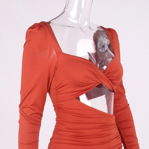 Détail d'une robe orange caramel à manches longues avec découpe et fronces latérales