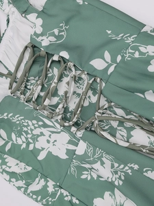 Detailansicht der Retro-Schnürung und des weißen Blumenmusters auf dem grünen Kleid