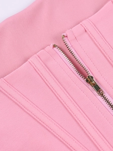 Detail of pink bandage crop top showing gold metal zipper and reinforced stitching