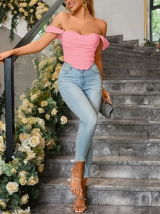 Detailed close-up of pink boned corset top with ruched fabric and off-shoulder design