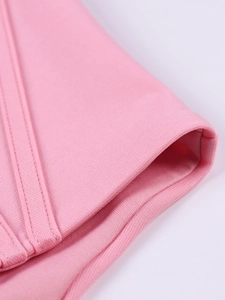 Detail of pink crop top fabric featuring high-density knit texture and double stitching